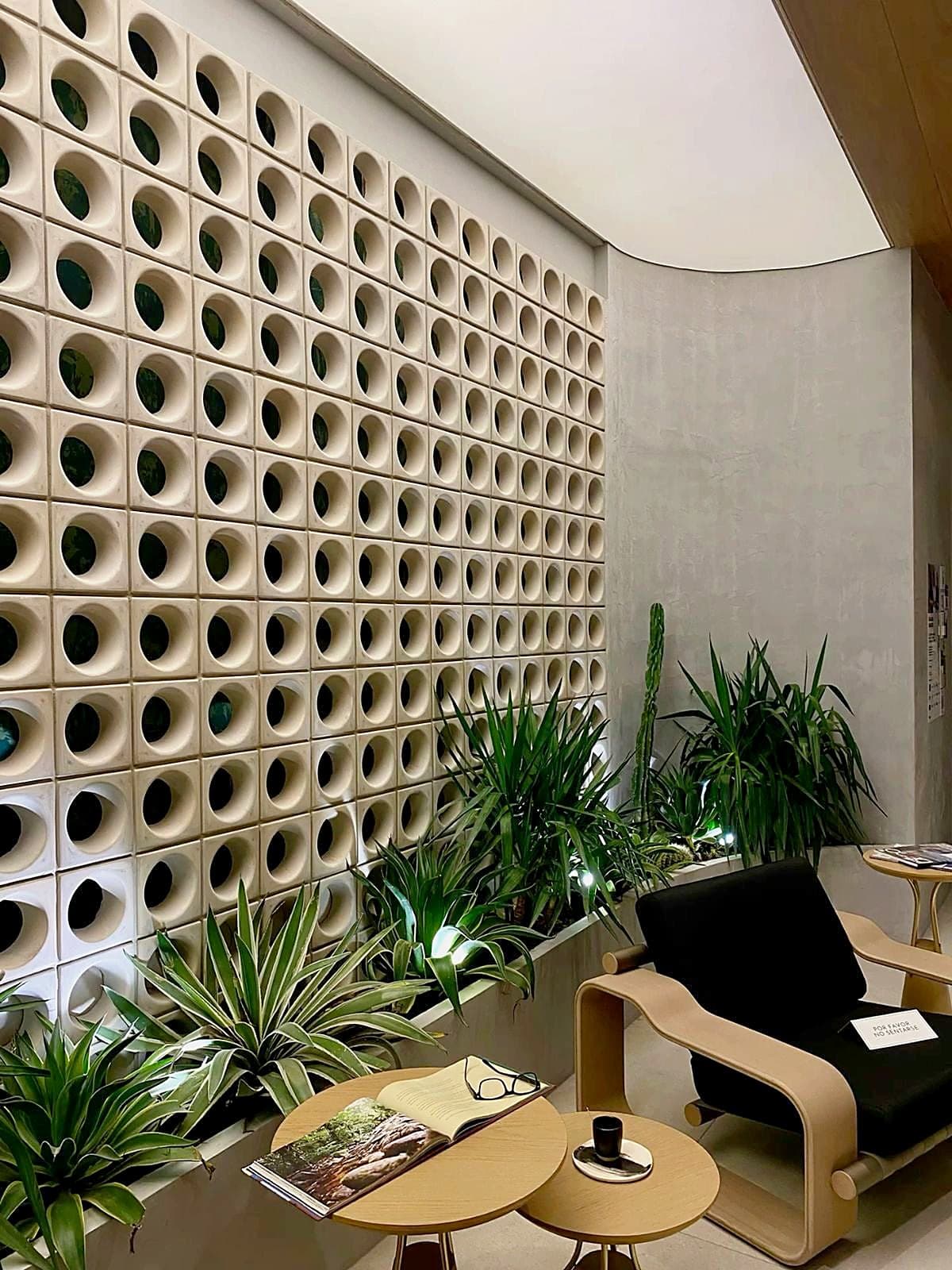 Muro interior de cobogó de círculos con jardín y sillón